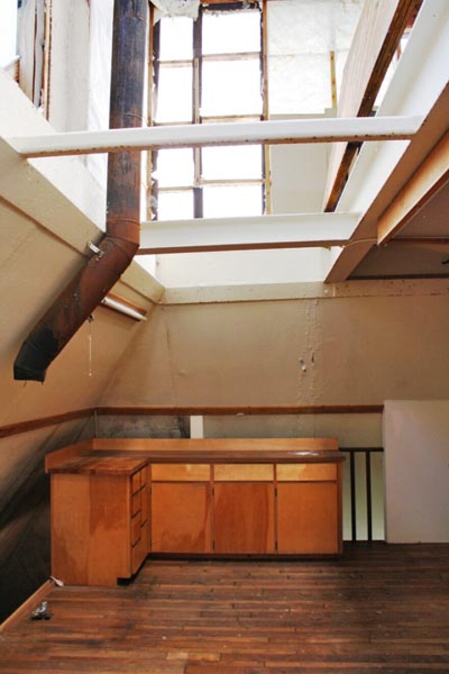 This pyramid shaped home in north Idaho was built out of concrete and steel beams, entirely underground. In this picture, an open hatch above the kitchen allows natural light in. Photo by Jessica Robinson
